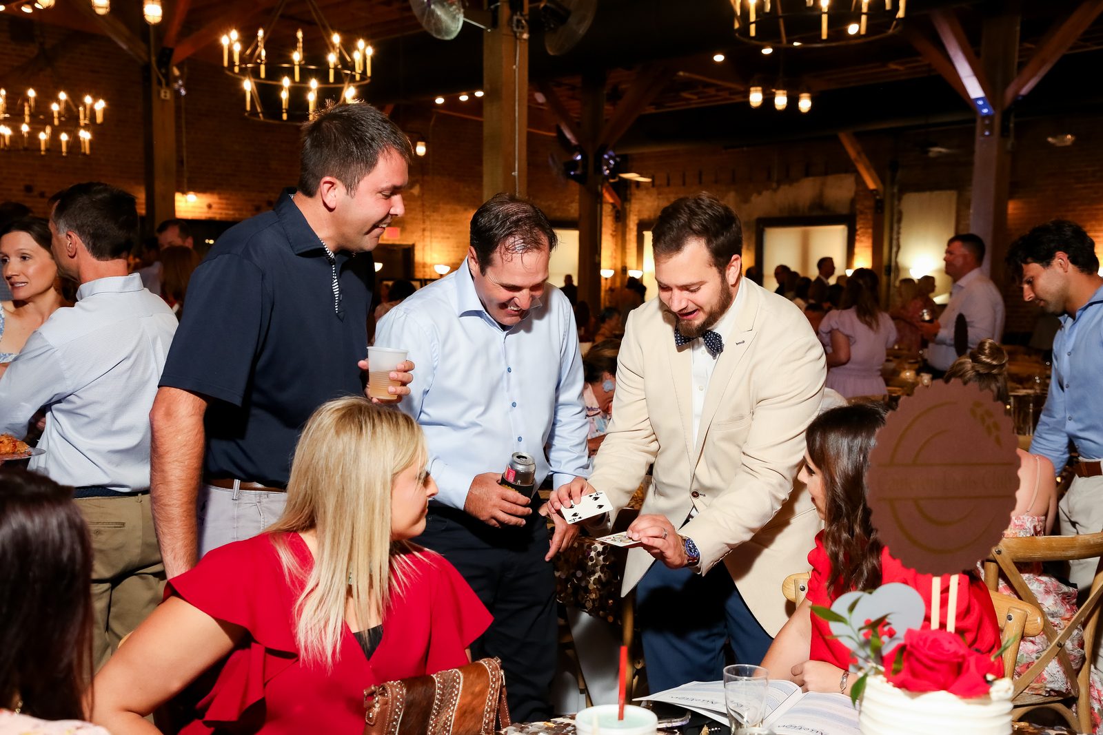 Guests gathered around a table for close-up magic